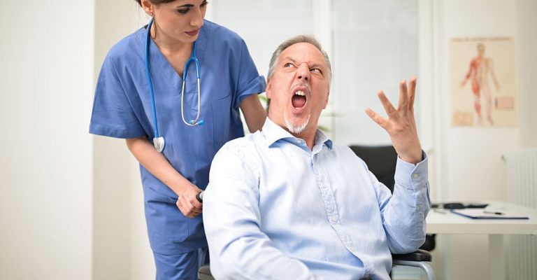 Portrait of a disabled patient screaming to a nurse